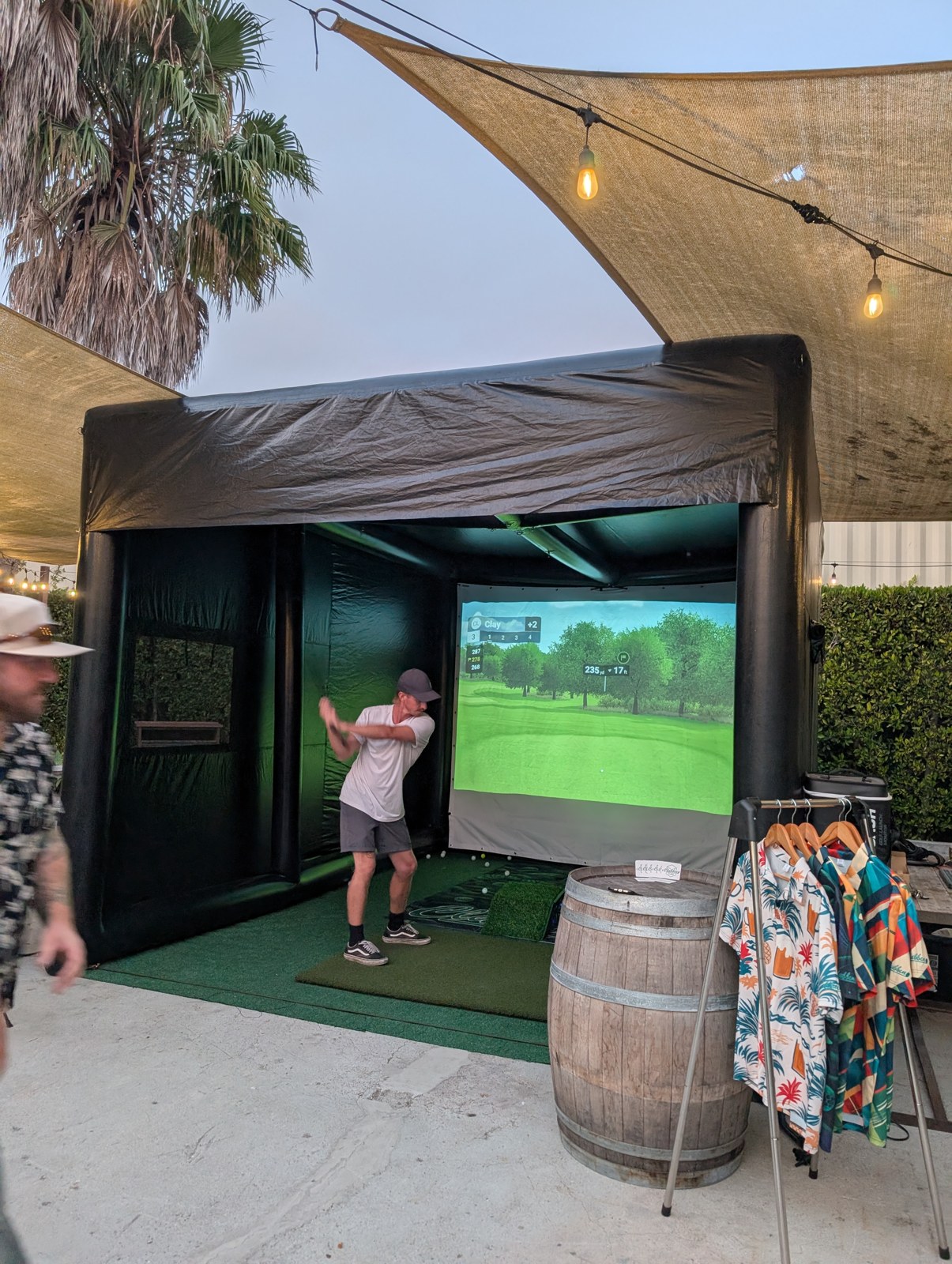 A golfer following through on a shot in the Clubbin Cube at Topa Topa